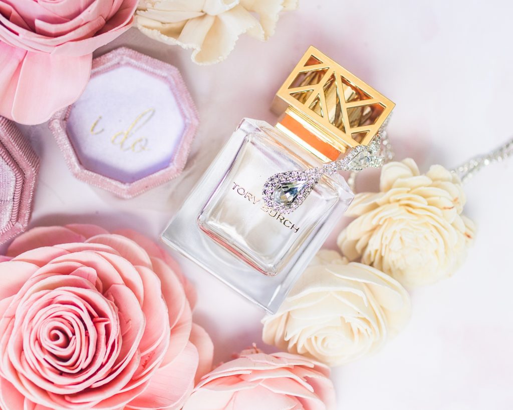 details of perfume, necklace, and flowers from the wedding day