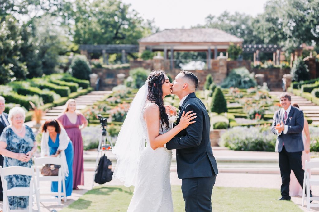 FWBG couple first kiss after DFW micro wedding in the rose garden