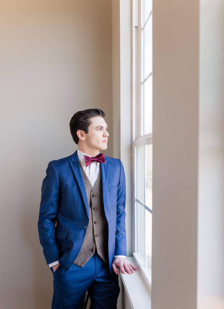 Groom portrait near window in blue suit