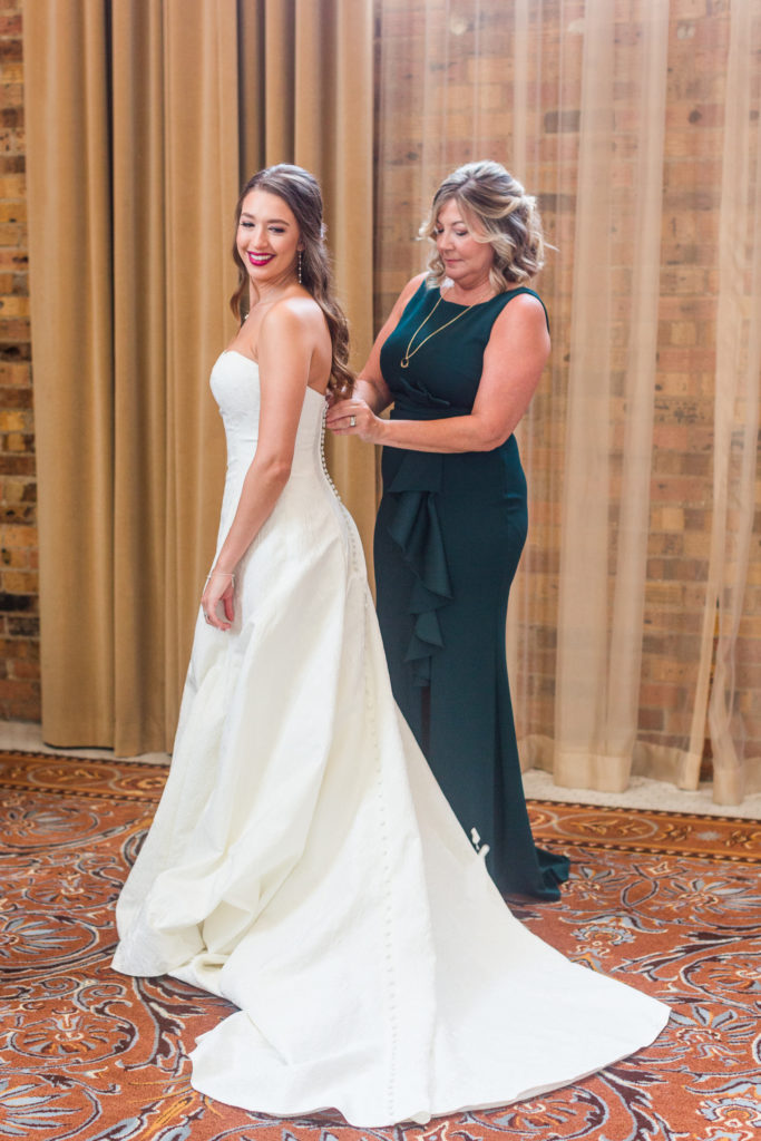 Mother of Bride helps daughter in gown at Dallas Union Station