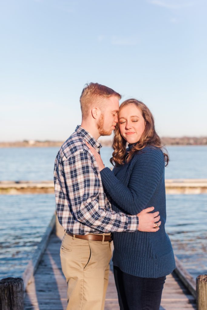 Couple cozying up on White Rock Lake dock during engagement session.